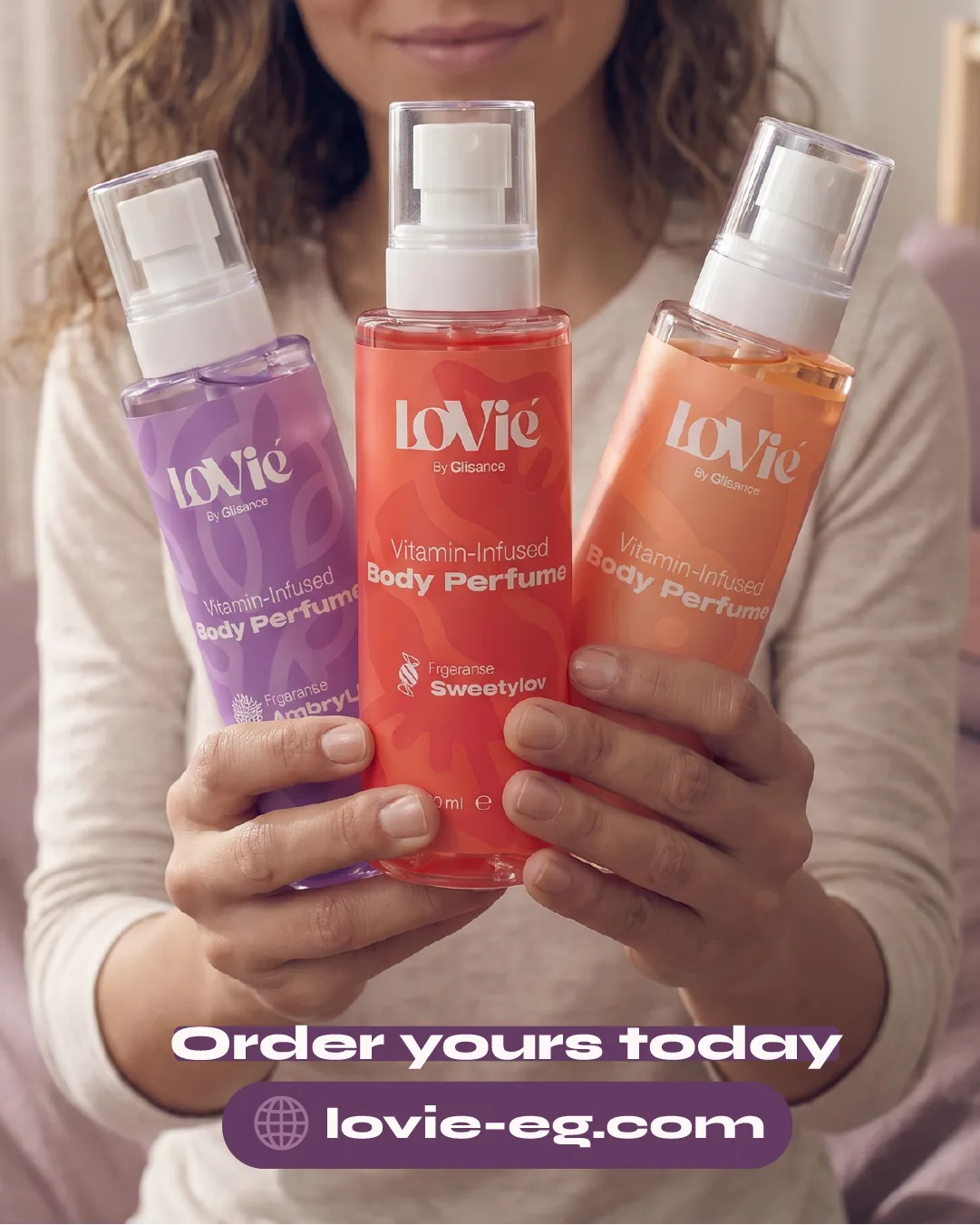 Portrait static: two hands holding the violet, red and orange body perfumes, headlined Order yours today with the store address.
