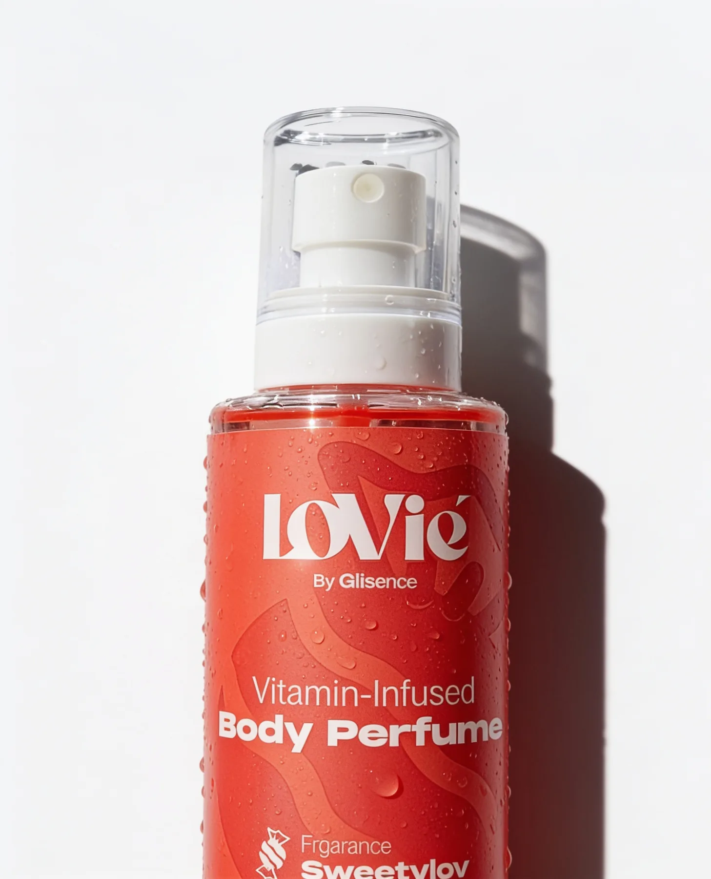 The scarlet Lovie body perfume covered in water droplets under hard directional light.
